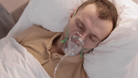 man with oxygen mask in bed