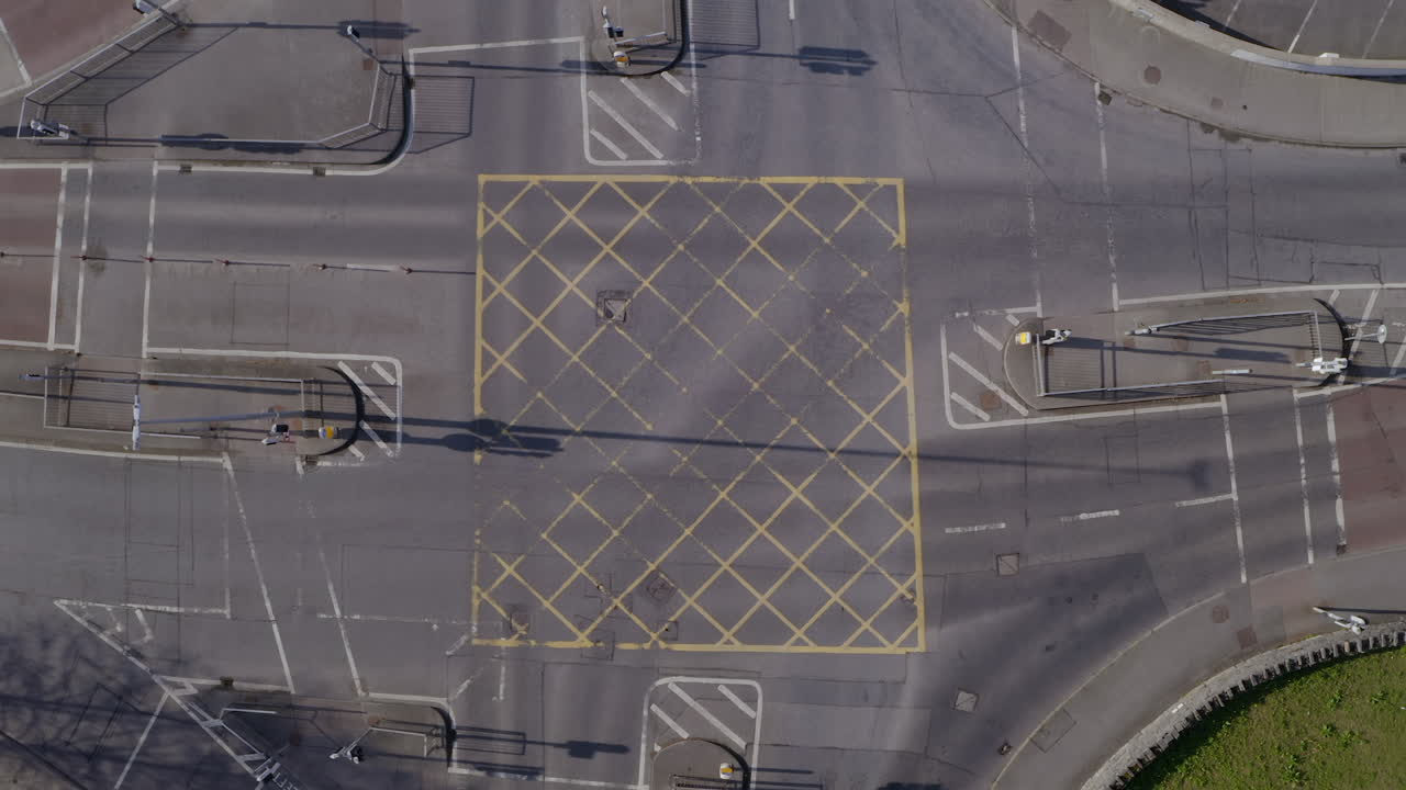 Timelapse at a major four way intersection on a sunny day. Aerial top down