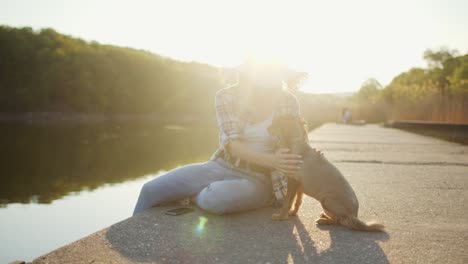 young woman relaxing by the lake with her dog