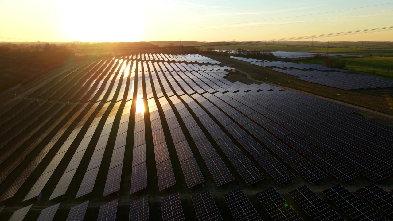 Droneoverflyvning, der flyver lavt over Tye Lane solcellepaneler med solglimt.