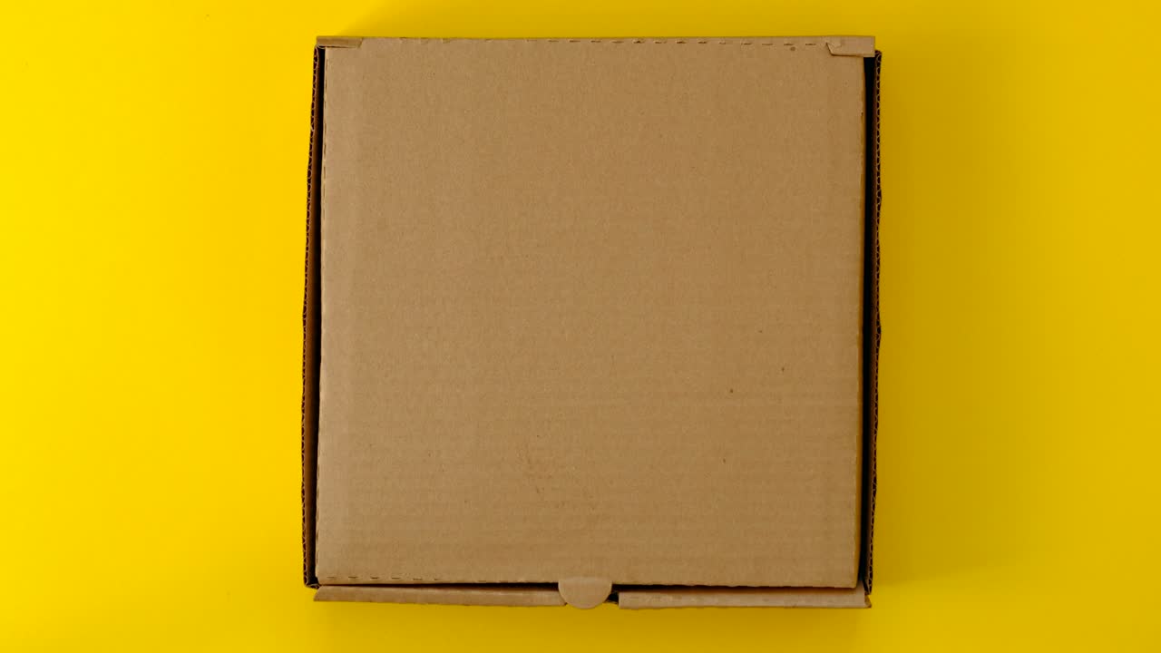 женские руки открывают и закрывают коробку с пончиками на желтом фоне