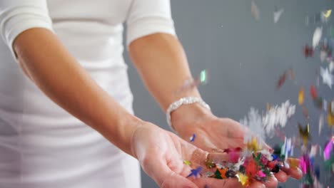 Mid-section-of-woman-playing-with-confetti-4k