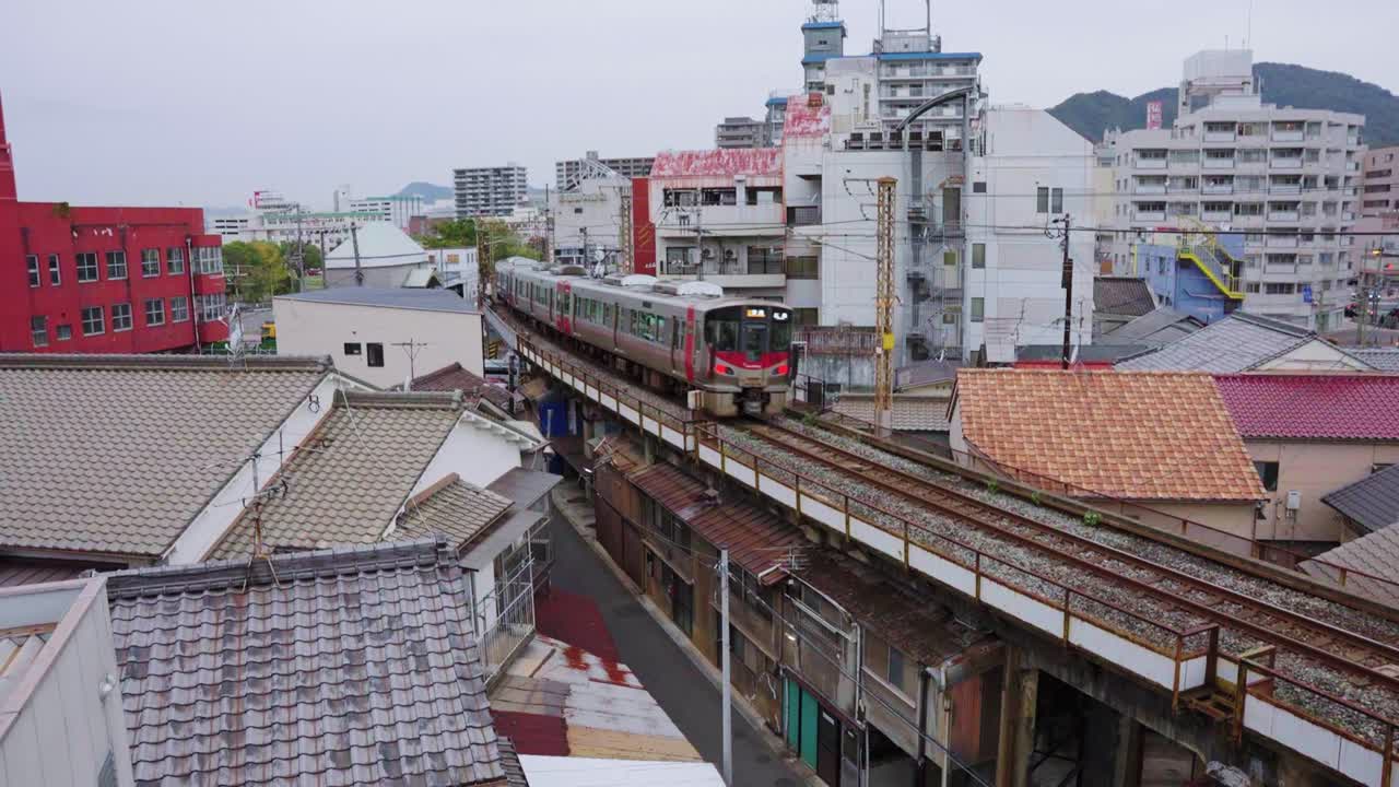 Kure City in Hiroshima, Early morning Train Passing Town on Rainy Day