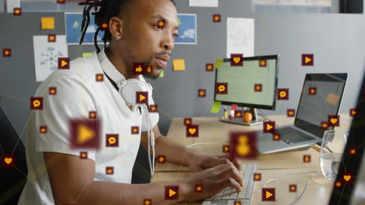 Animation of network of digital icons against african american man using computer at office