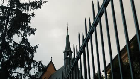 old church with piked fence in front and trees