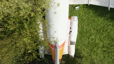 bird's eye aerial view of abandoned airplane in green field