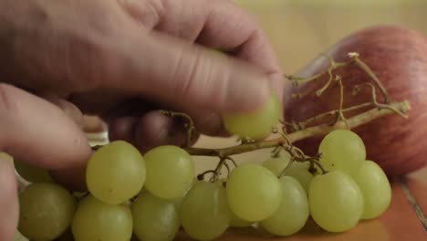 hand picking grapes with apple close up shot