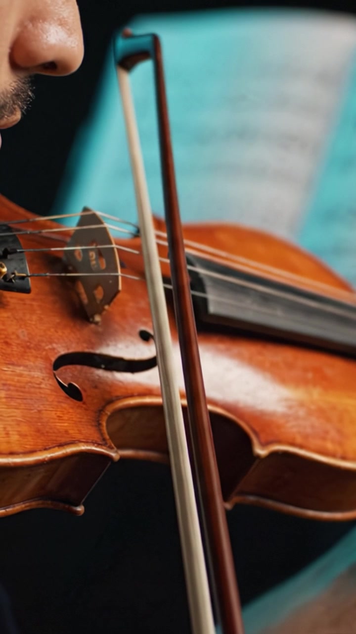 Captivating Performance of a Skilled Musician Holding a Violin, Showcasing Mastery of Technique and Emotion Through String Instrument Artistry in Close-Up Shots