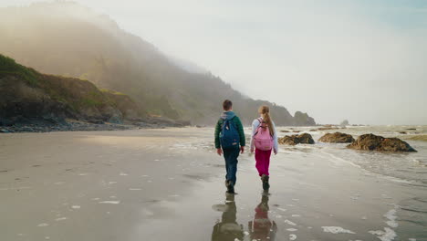 two children walking on a misty beach