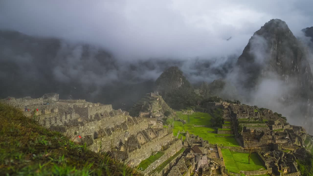 Machu Pichhu morning sunny sunrise low foggy fog cloud movement Peru Perú Time lapse jungle Hauny Picchu Mountain Inca temple ruins citadel ancient structure sanctuary tourist people guided tour pan