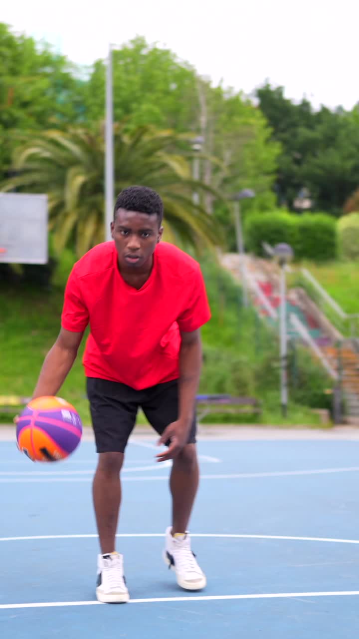 Basketball player dribbling ball on outdoor court