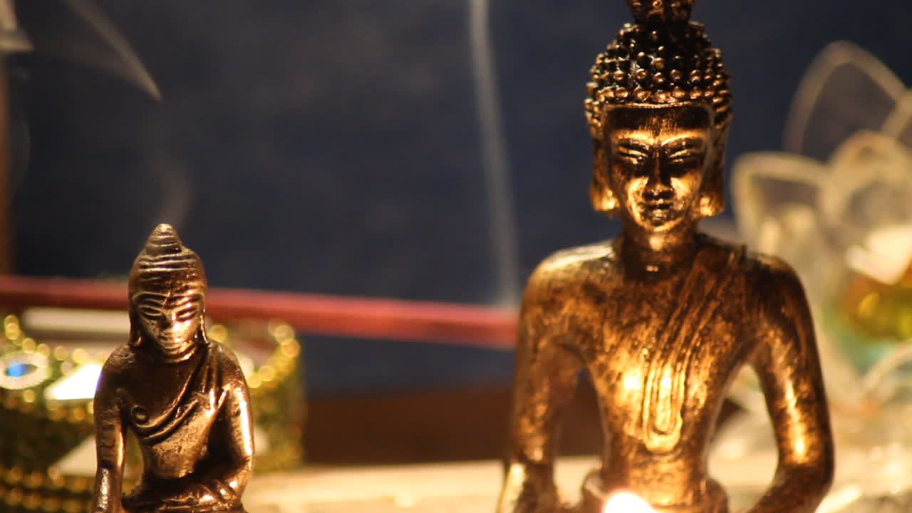 estatuas de buda meditando con velas de cerca 07