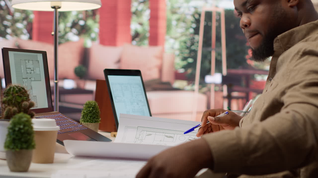 Owner of a tech startup searching for new office spaces by using blueprints