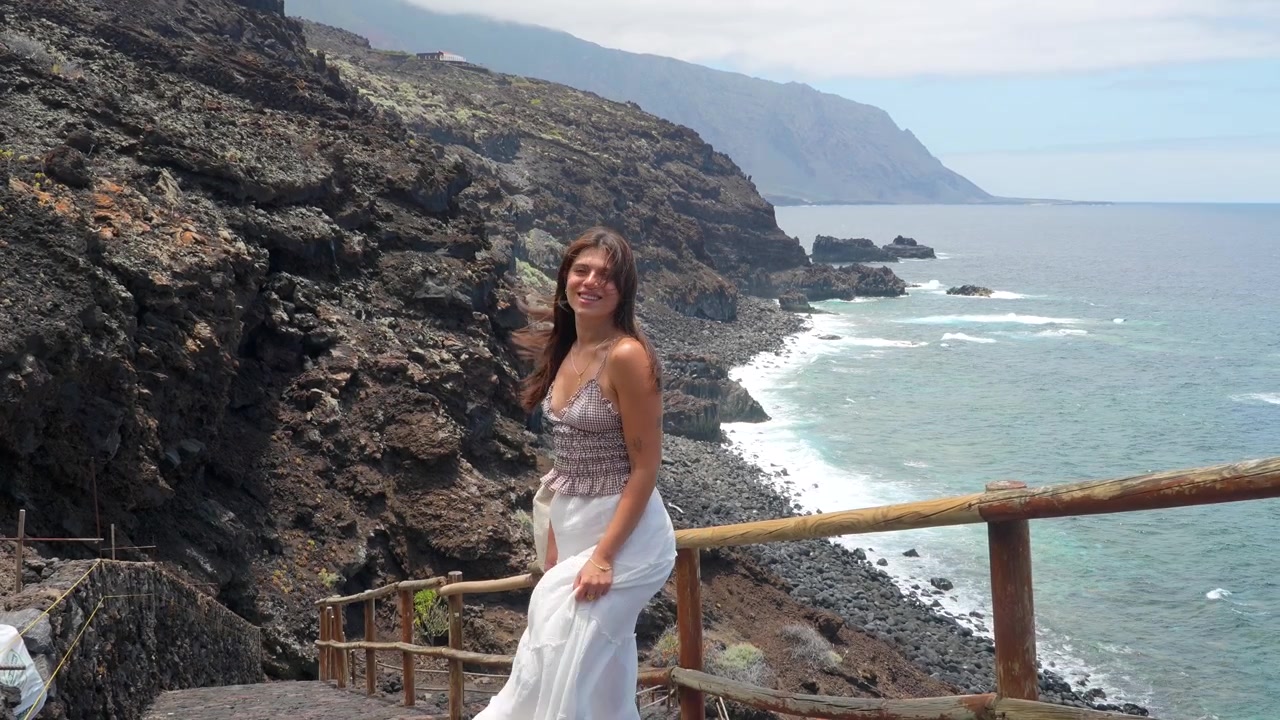 Young Woman Standing on Coastal Path Overlooking the Ocean