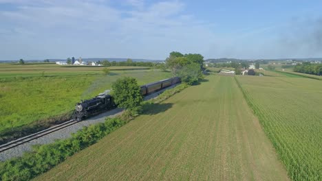 Strasburg,-Pennsylvania,-August-2019---Aerial-View-on-an-Approaching-Steam-Passenger-Train-in-the-Amish-Countryside-on-a-Summer-Day