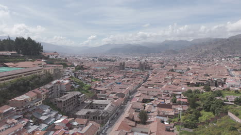 sideways moving drone shot above cusco peru on a cloudy day away from the city center log
