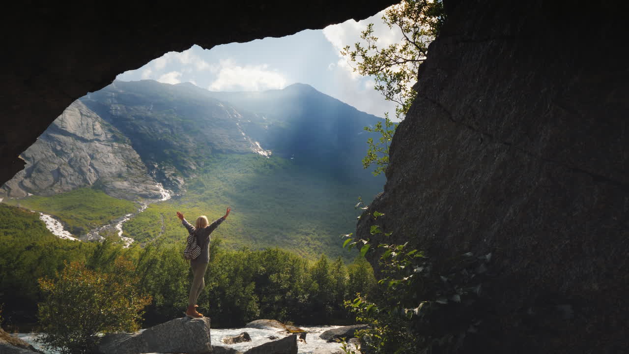 un viajero se encuentra en un valle fabulosamente hermoso entre altas montañas y vistas a través de cascadas