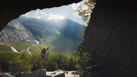 a traveler stands at a fabulously beautiful valley among high mountains and waterfalls view through