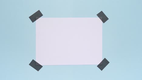 Top down stop motion white note taped on blue background, making center copy space