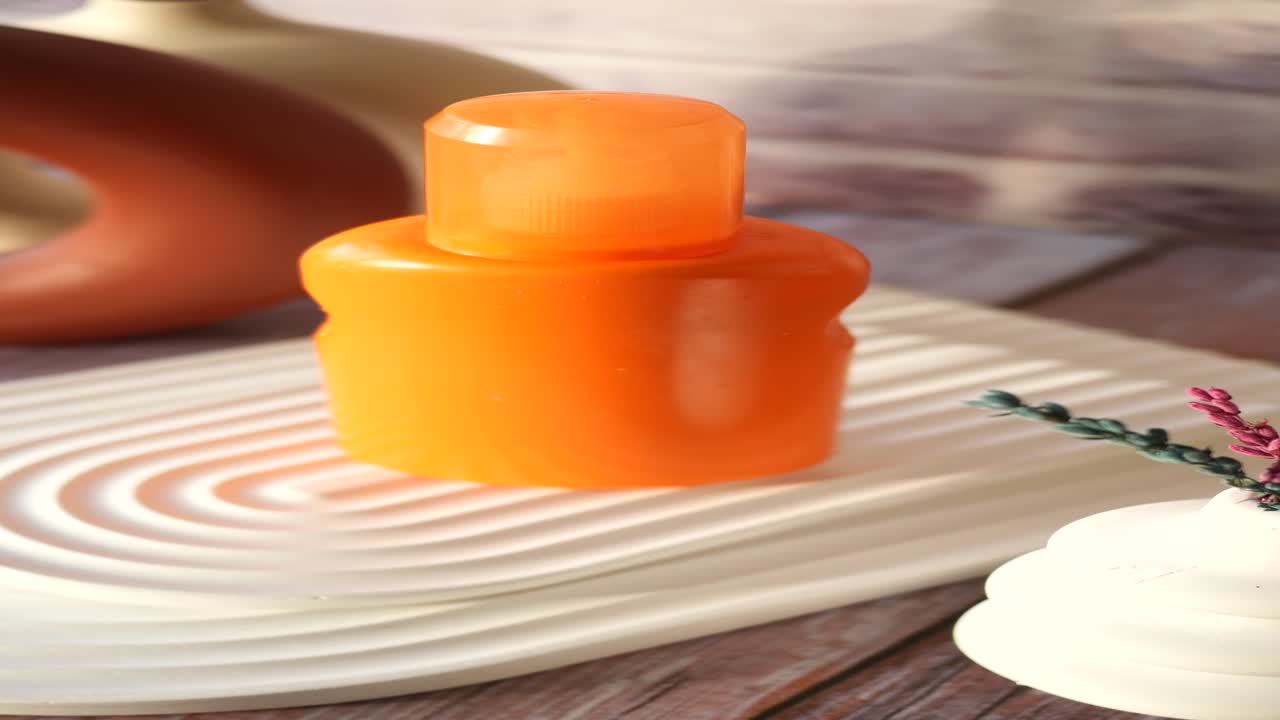 Orange Bottle Skincare Product on Tray with Decor