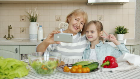 abuela y nieta tomando una selfie en la cocina