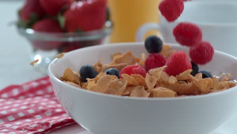 blueberries and raspberries falling into cereal in slow motion