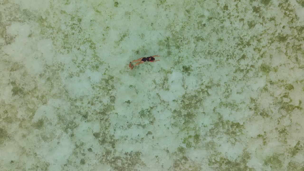 Aerial capture of woman enjoying crystal-clear water, Komodo Island