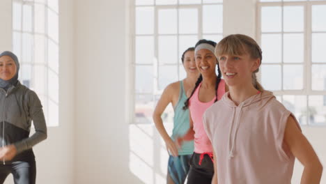 Feliz-Mujer-Caucásica-Bailando-Grupo-De-Personas-Sanas-Disfrutando-Del-Entrenamiento-Practicando-Movimientos-De-Coreografía-Con-Un-Instructor-De-Baile-Divirtiéndose-En-El-Gimnasio