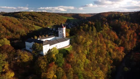 state chateau hradec nad moravici and white tower surrounded by autumn forests in czechia, czech republic