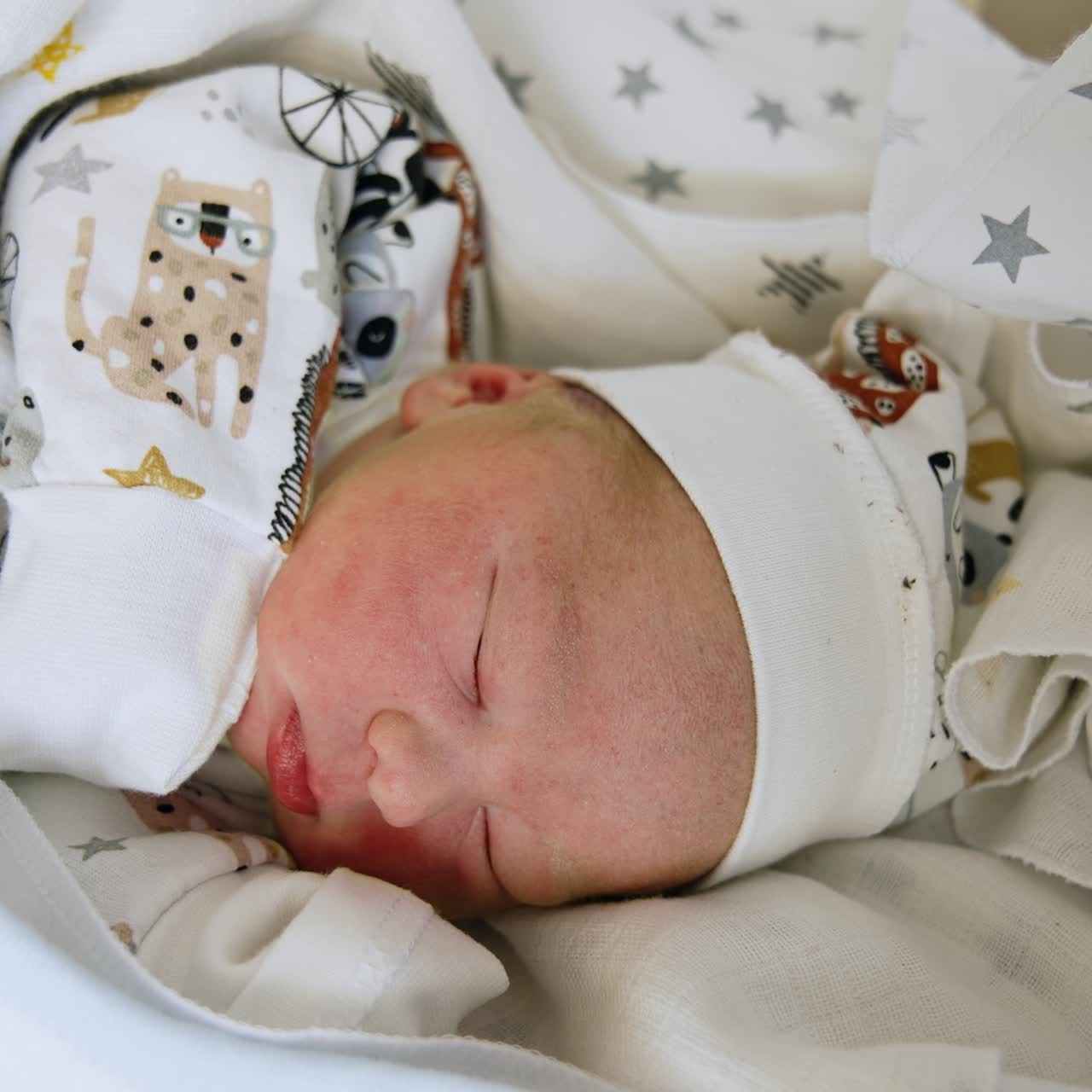 Neonato che dorme serenamente, coperto da lenzuola e coperte. Primo piano. Adorabile bambino caucasico sdraiato su un fianco. Primo piano