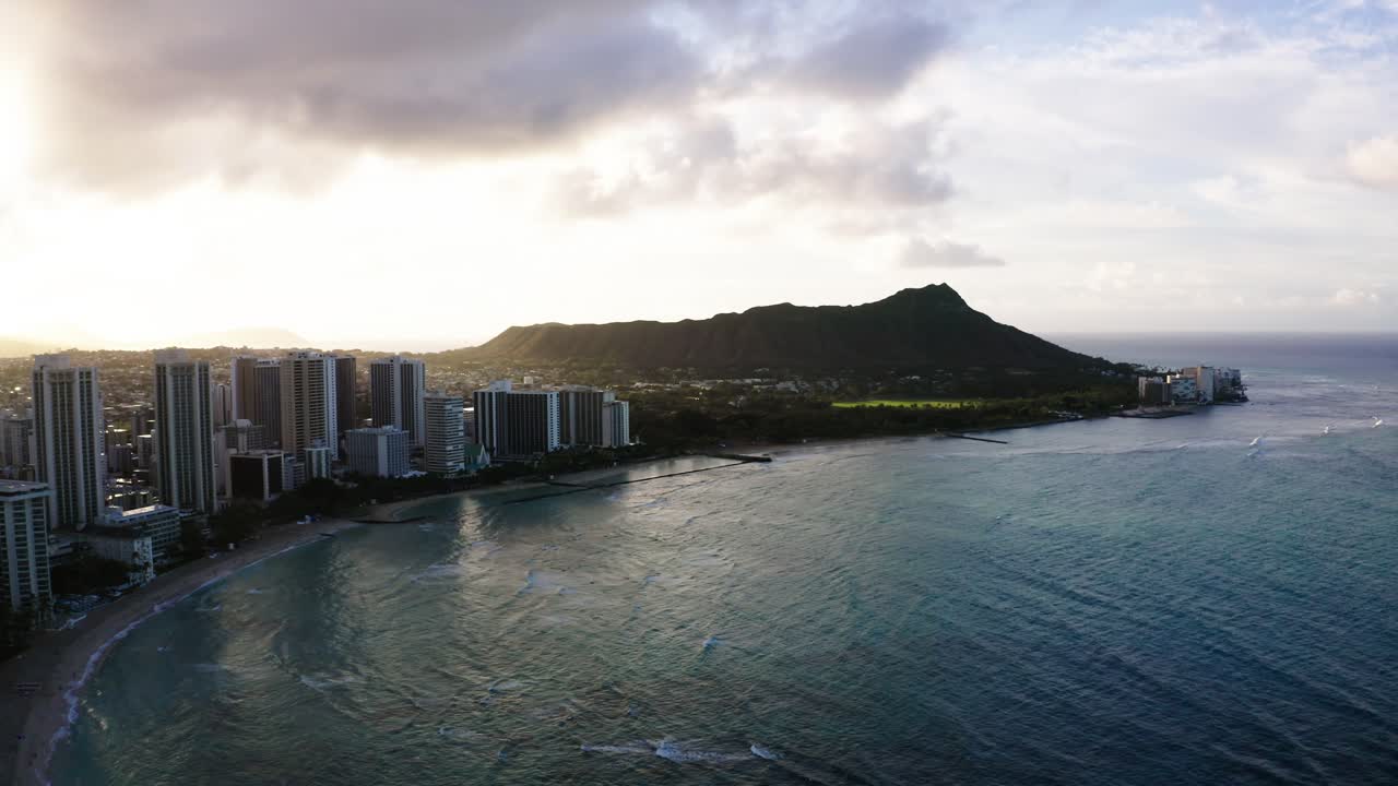 Vista aerea con drone di Waikiki Beach e dei suoi complessi turistici con Diamond Head in lontananza.