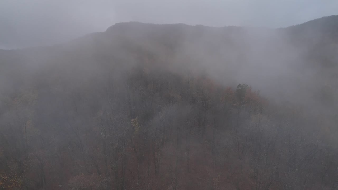 Sumu laskeutuu metsäisten kukkuloiden ylle Castelletto Val Tollassa, Emilia Romagnassa, Italiassa, luoden salaperäisen ja rauhallisen syystalvimaiseman paksulla usvapeitteellä Mignano-järven lähellä.