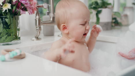 mother bathing crying baby with mom washing little infant having tantrum