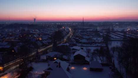 Flug-über-Eine-Stadt,-Die-Von-Einem-Fackelschein-Bei-Sonnenuntergang-Beleuchtet-Wird