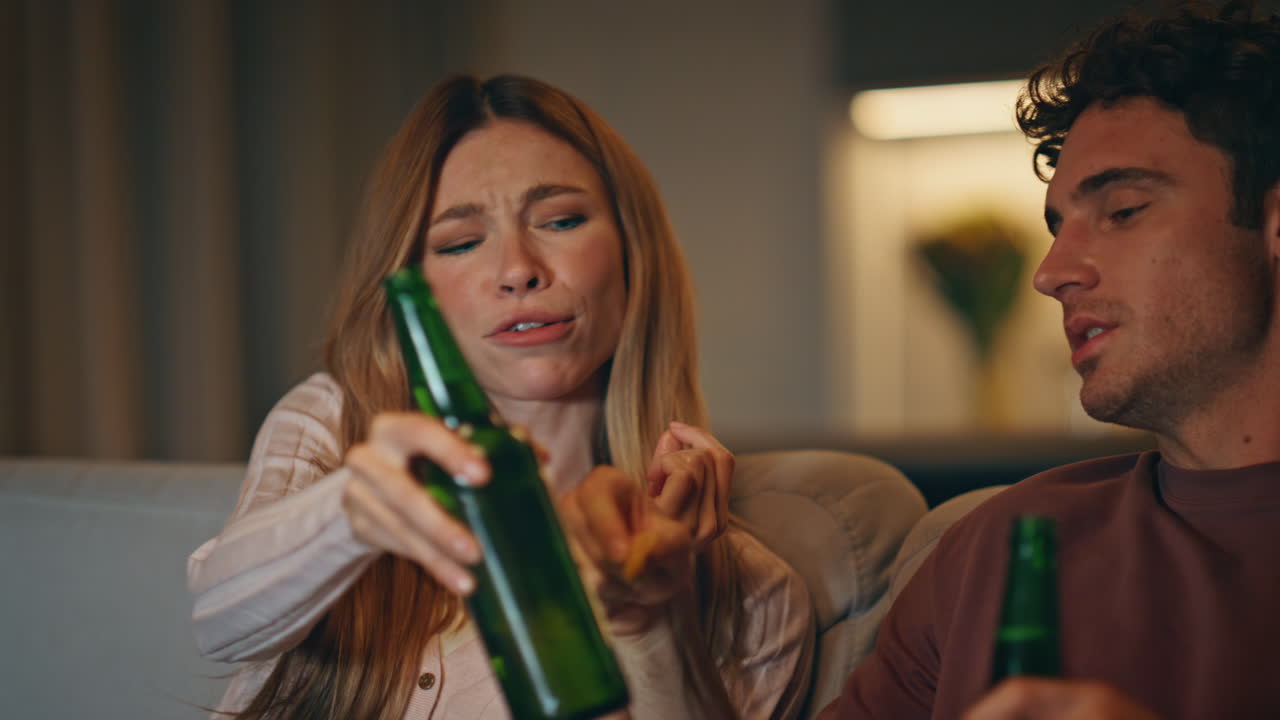 Couple hands taking chips from bowl home evening closeup. Friends clinking beer