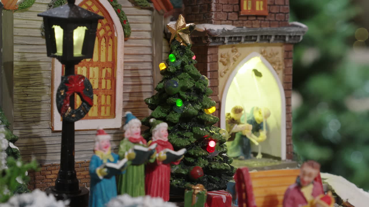 Scena festiva di villaggio natalizio in miniatura con cantori e luci lampeggianti