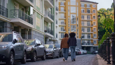 married couple walking together at modern city residential complex rear view.