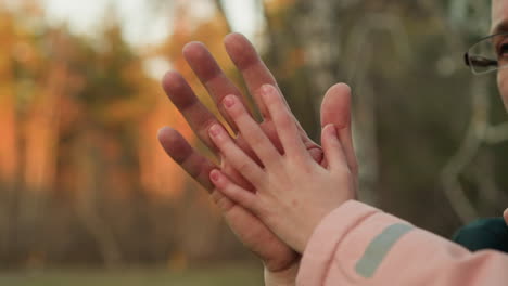 una toma de primer plano de un momento conmovedor donde la mano de un niño descansa suavemente en la de un adulto, simbolizando la confianza, la conexión y el calor