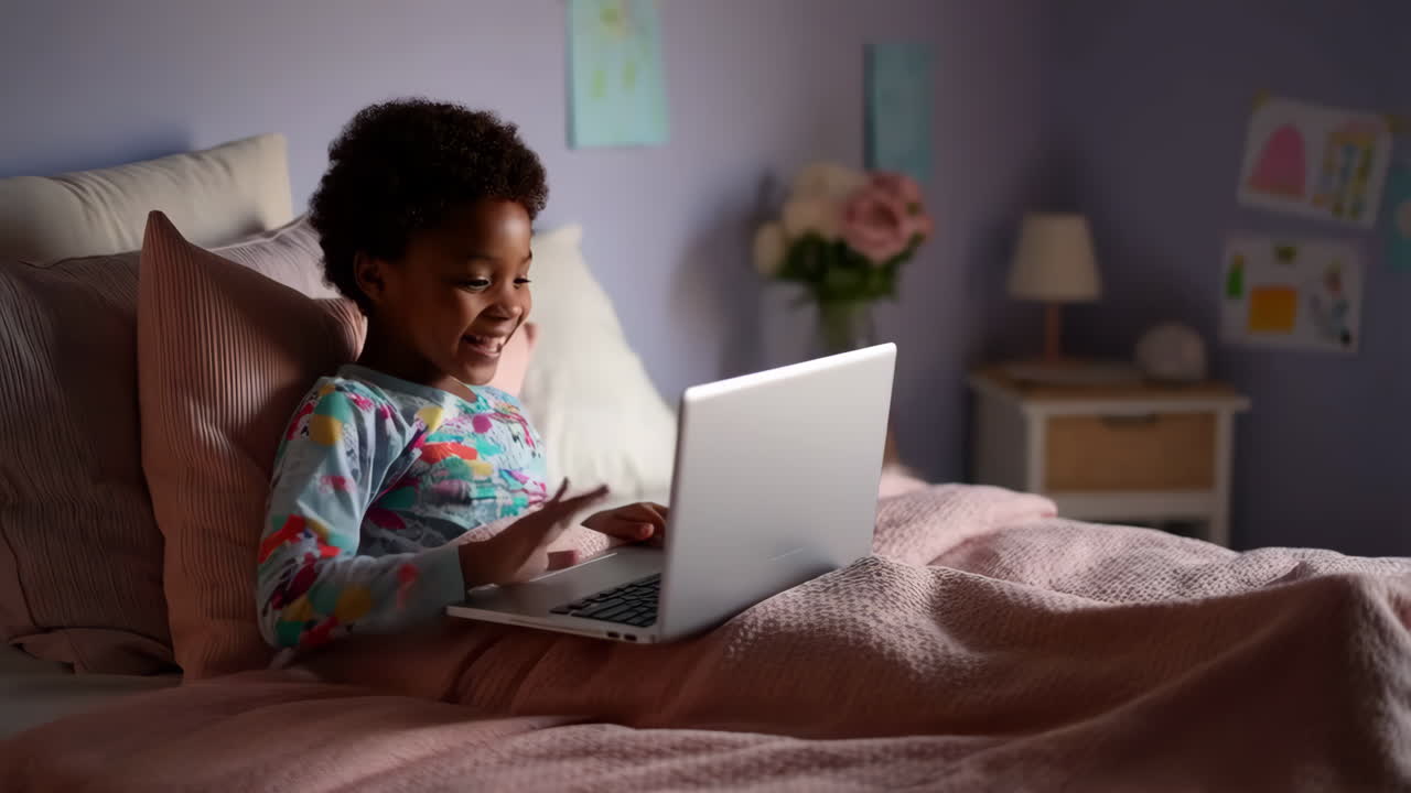 Happy Child Using Laptop in Bed at Night
