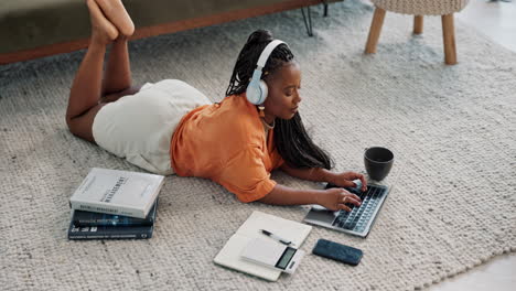 laptop, headphones and young woman on the floor