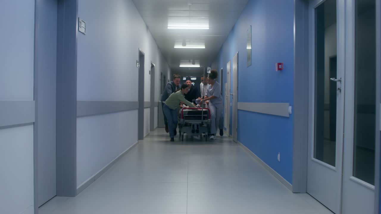 personal médico que mueve al paciente en el pasillo del hospital