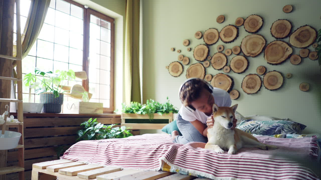Woman relaxing with her dog in her bedroom.