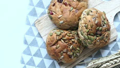 assortment of seed and cranberry buns on wooden cutting board