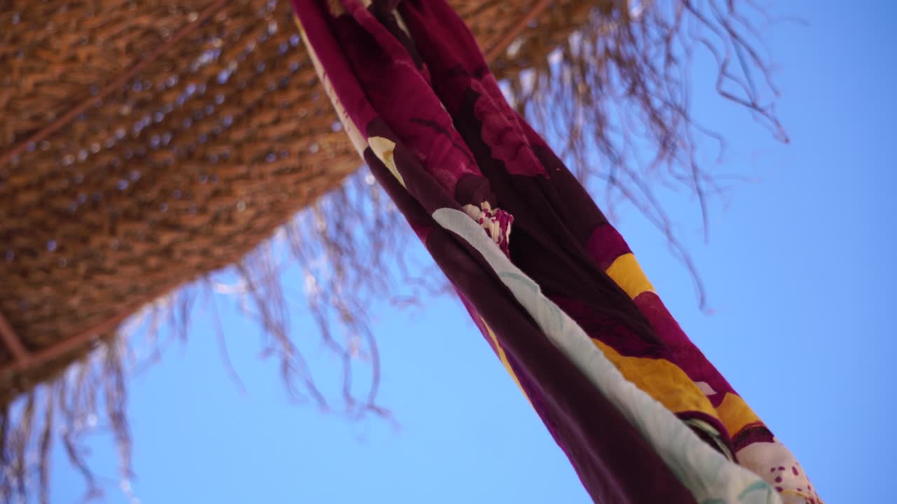 Sun rays and breeze passing beach umbrella with clothes flying 3