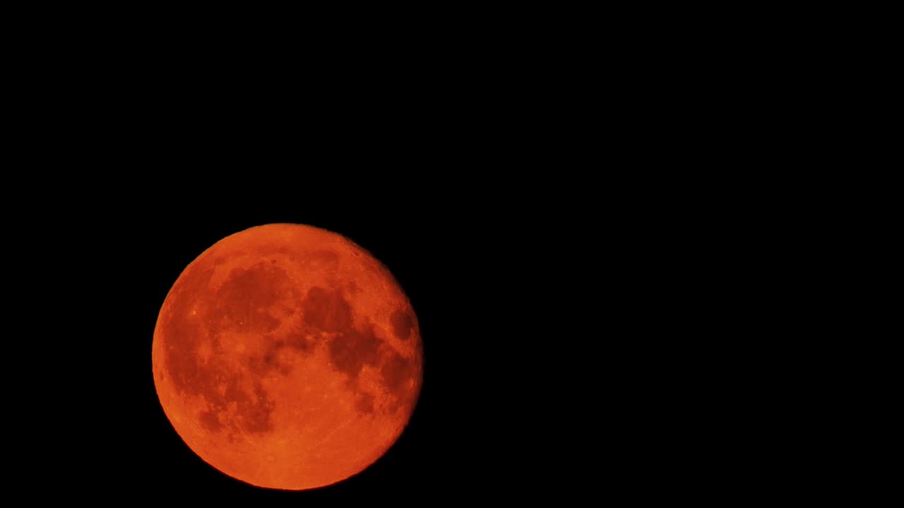 A red dramatic moon in the dark sky