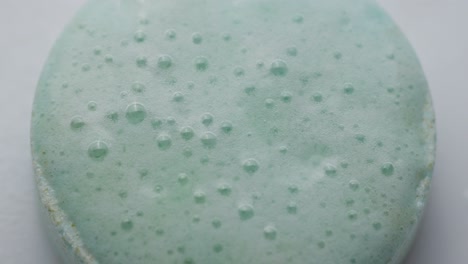 effervescent tablet reacting in water, forming bubbles on the surface, macro view