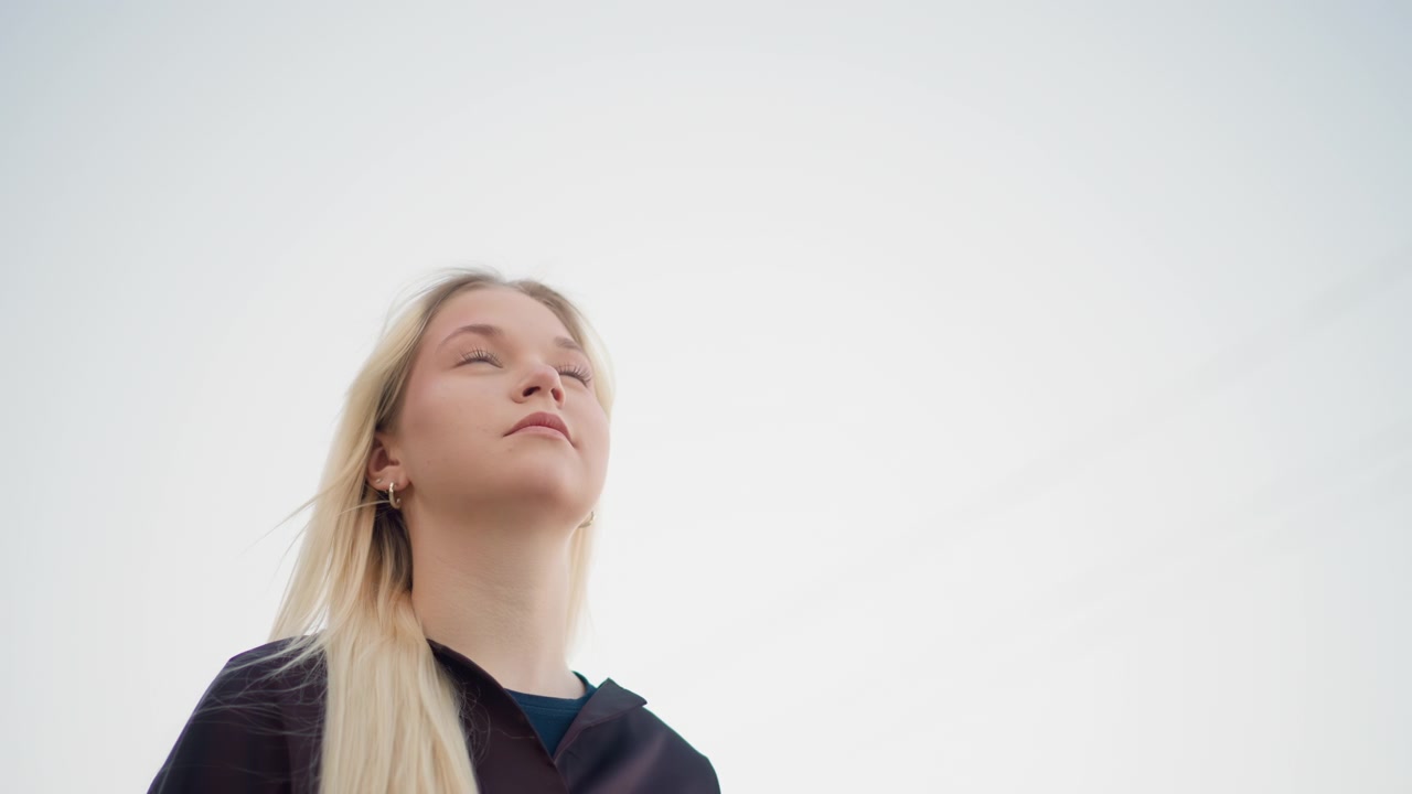 Young Blonde Woman Looking Upwards Outdoors