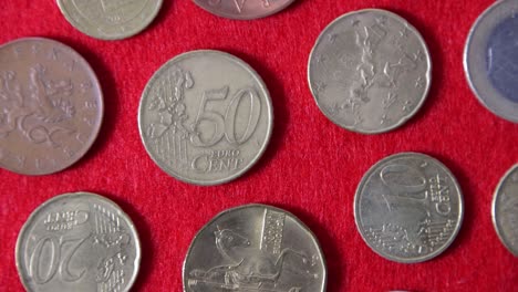 top view of a pattern of european coins on a red cloth, close-up, turntable