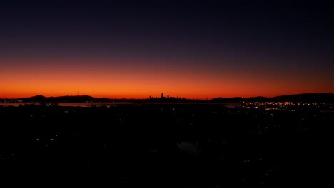 Ein-Schneller-Zeitraffer-Des-Sonnenuntergangs-Hinter-Der-Großstadt-Und-Dem-Verkehr-Darunter