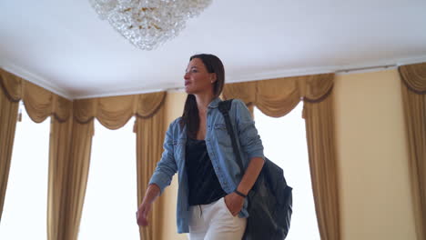 modern girl visiting historic building. young lady walks by the ball room where couple in old-fashioned clothes perform a dance. past meeting present.